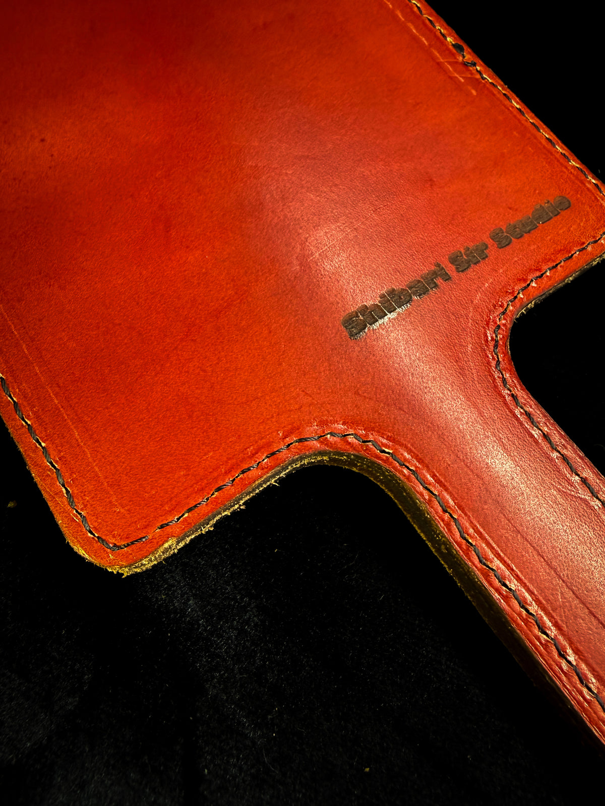 Red leather paddle with black crocodile inlay, detail