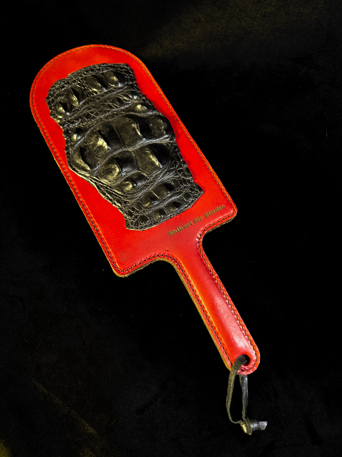 Red leather paddle with black crocodile inlay, handmade in Australia
