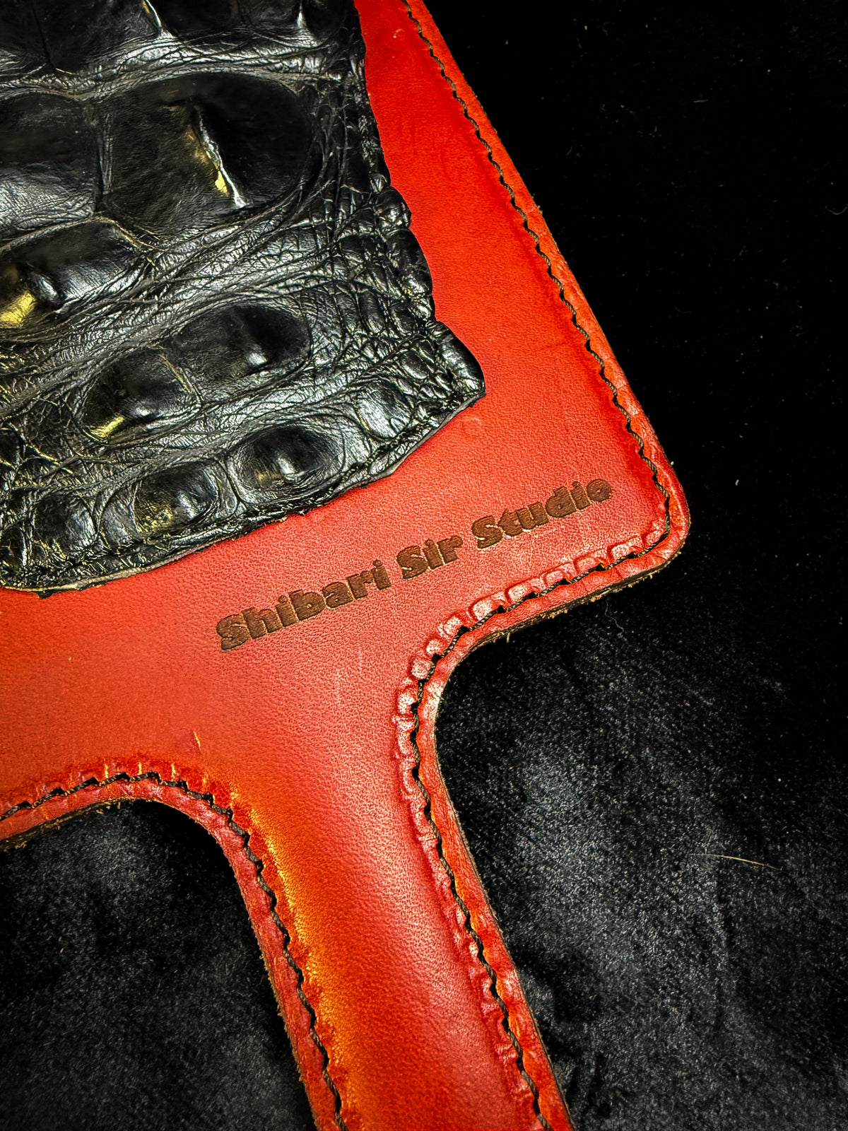 Red leather paddle with black crocodile inlay, detail