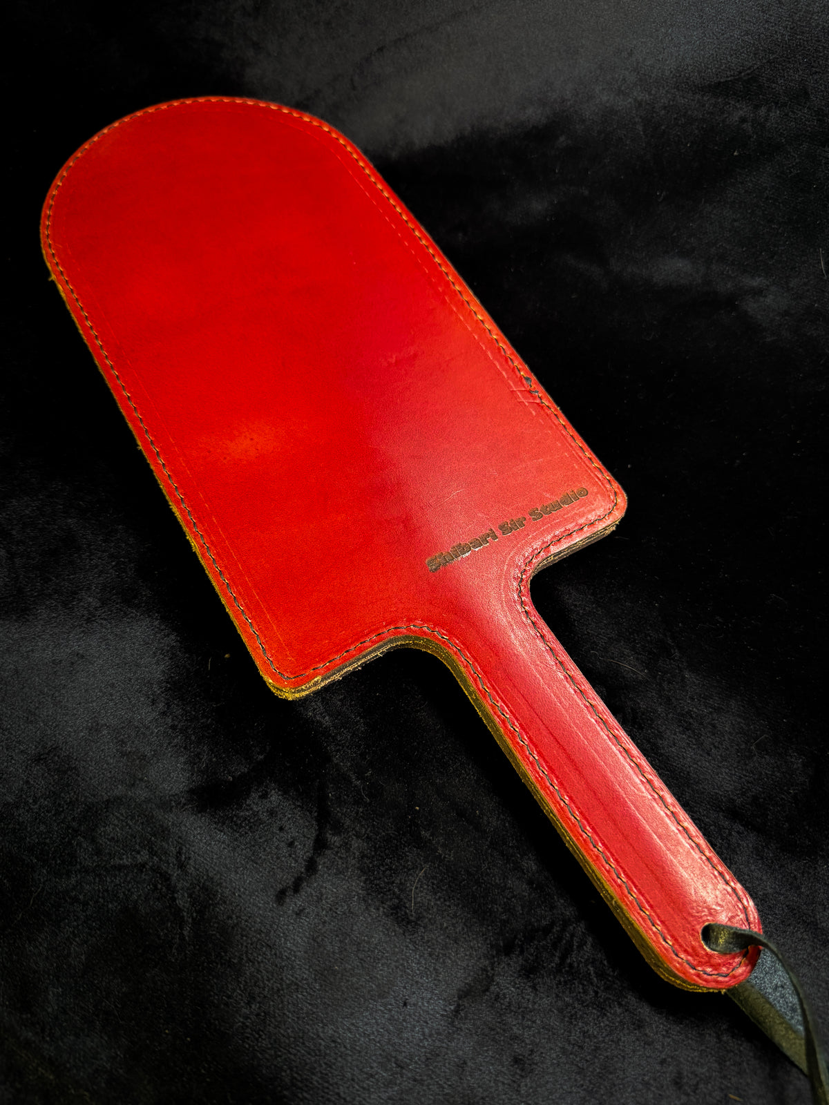 Red leather paddle with black crocodile inlay, detail