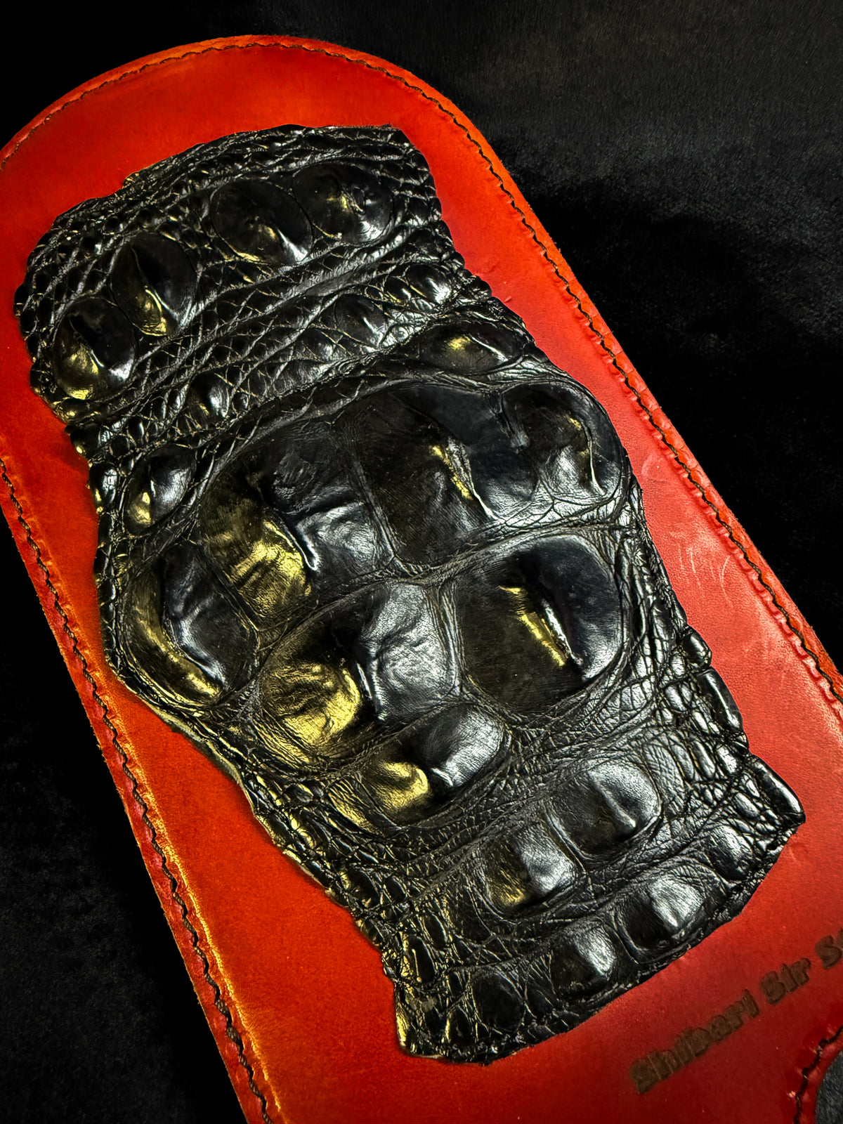 Red leather paddle with black crocodile inlay, detail